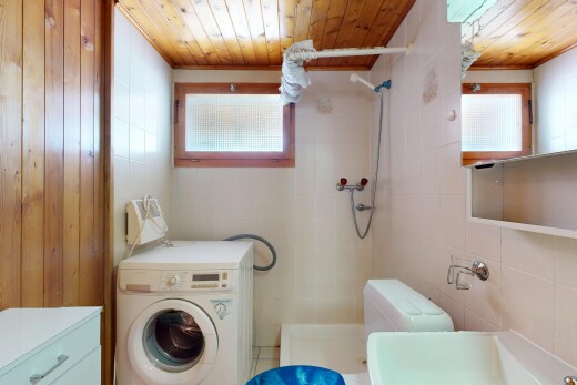 full bath with a tile shower, washer / clothes dryer, tile walls, wooden ceiling, and plenty of natural light