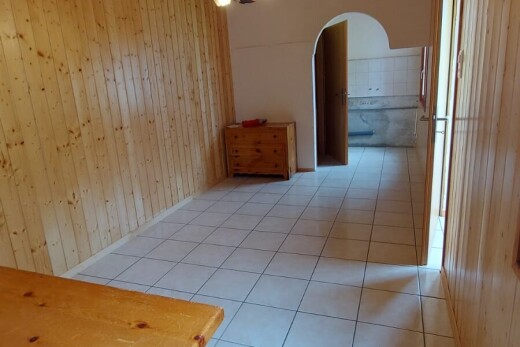 corridor with tile patterned floors, arched walkways, and wooden walls