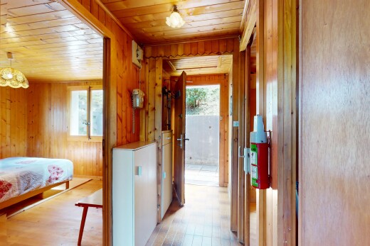 room / bedroom featuring multiple windows, light wood-style floors, wood walls, and wooden ceiling