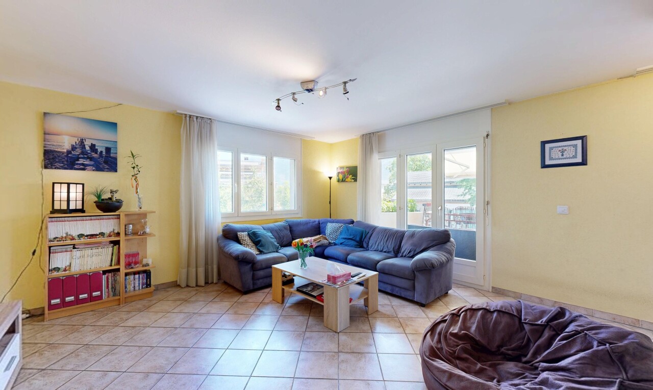 salon avec éclairage sur rail, cloison sèche, drywall, sol en carrelage, et tile floor