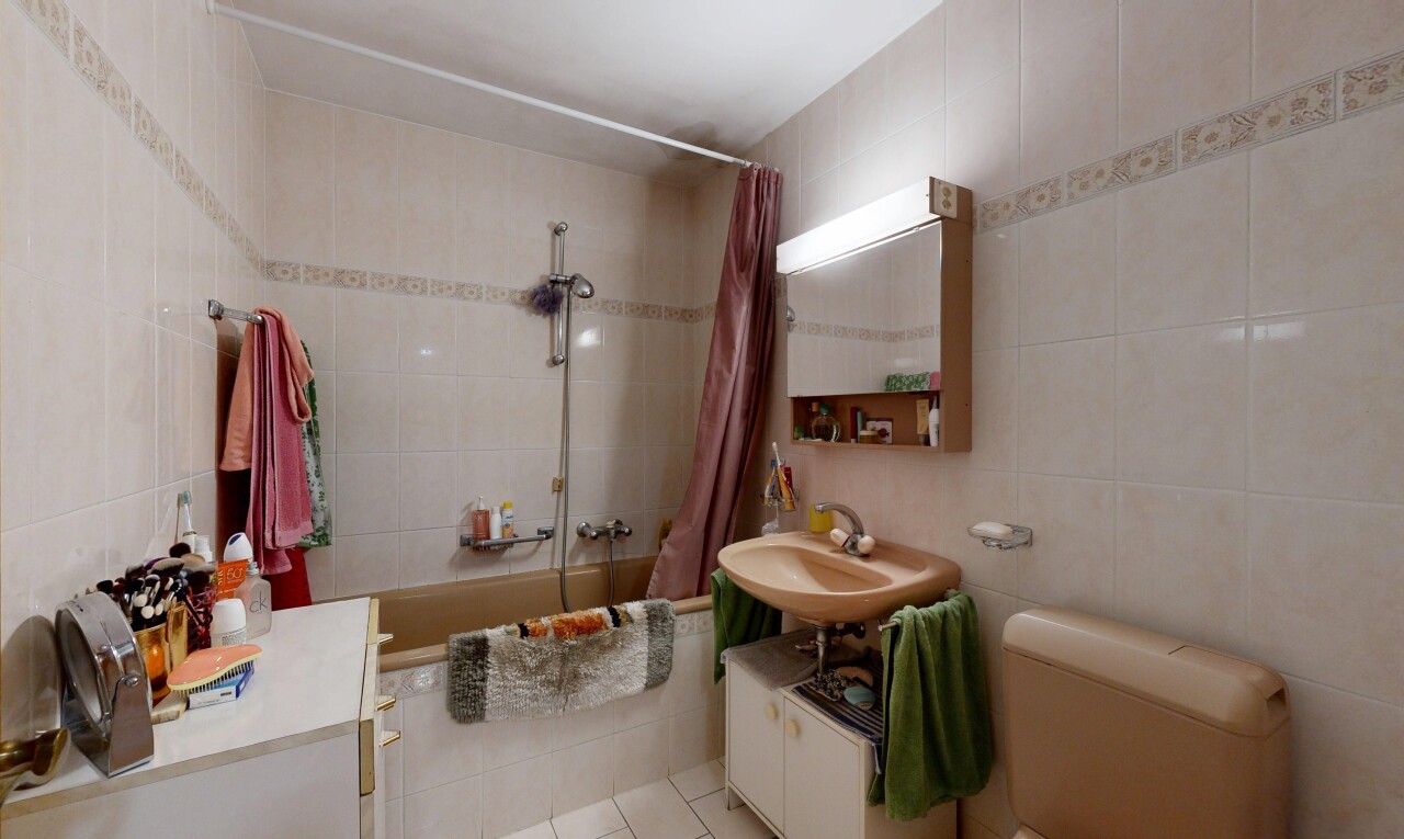 salle de bains avec tile wall, mur en carrelage, miroir, douche-bain combinés, et salle de bain complète