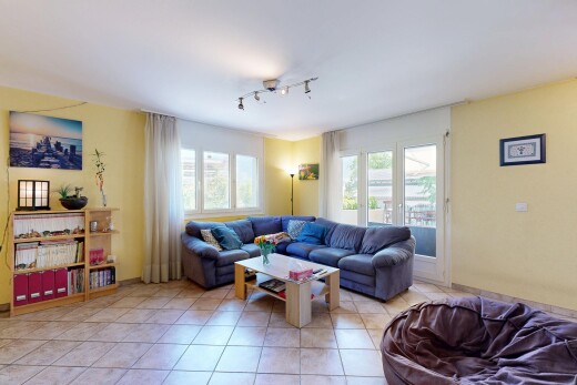 salon avec éclairage sur rail, cloison sèche, drywall, sol en carrelage, et tile floor