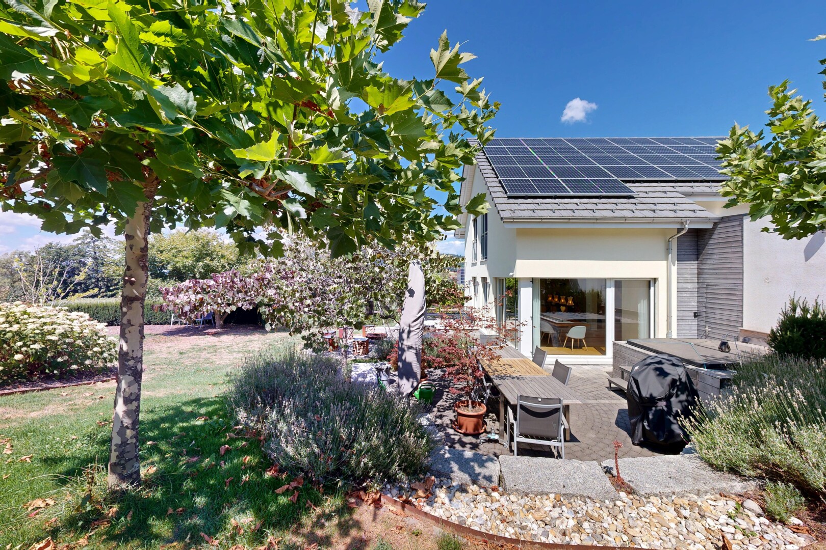 view of home with solar panels, a patio, and a yard