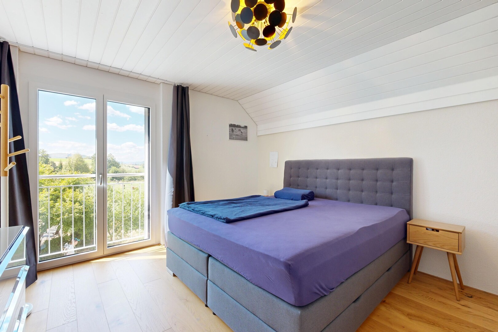 room with light wood finished floors, vaulted ceiling, and access to outside