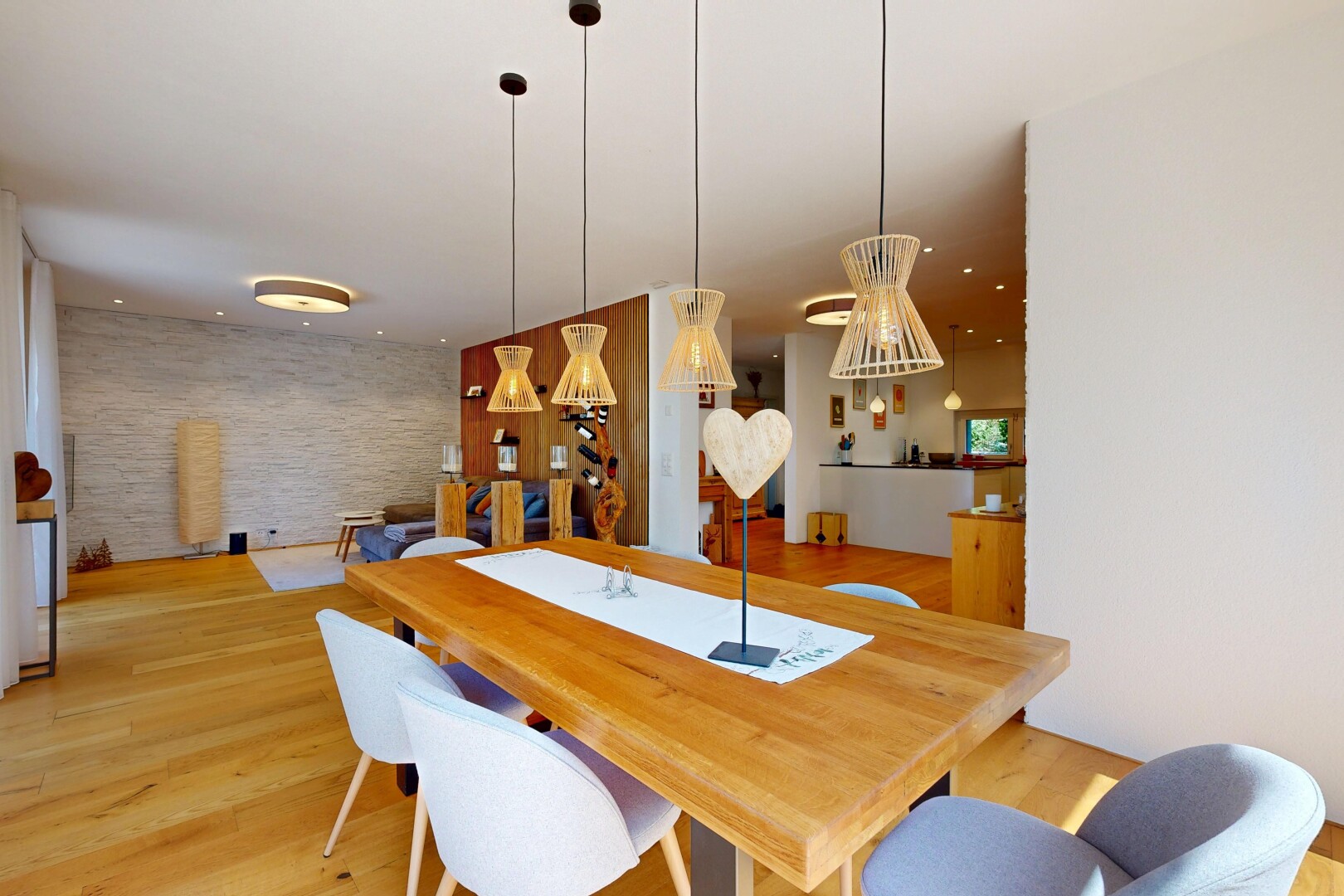 dining space with light wood-type flooring, decorative light fixtures, and an accent wall