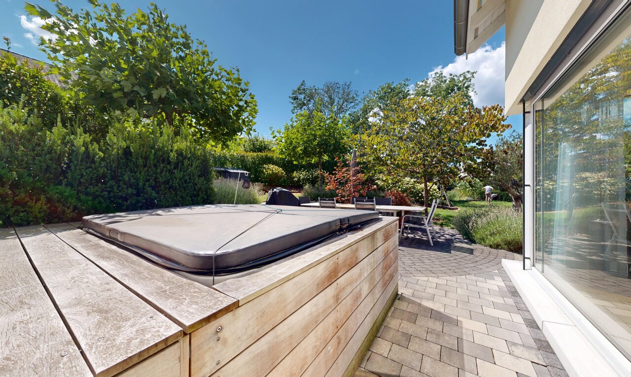 terrace with a hot tub and a patio