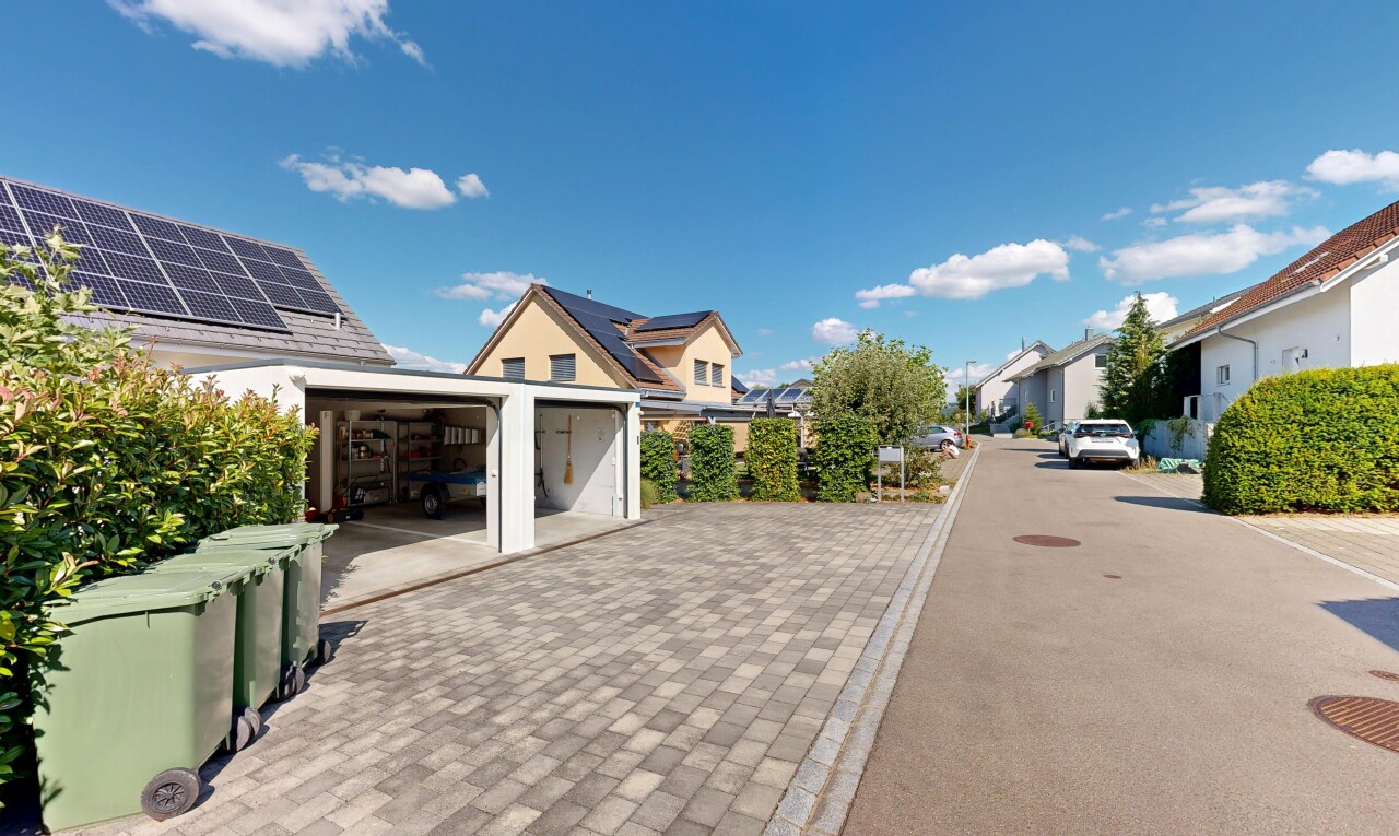 view of property featuring a residential view and decorative driveway
