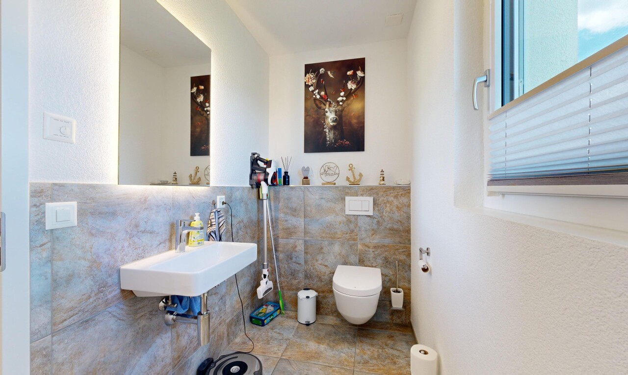 half bathroom with tile walls and a sink