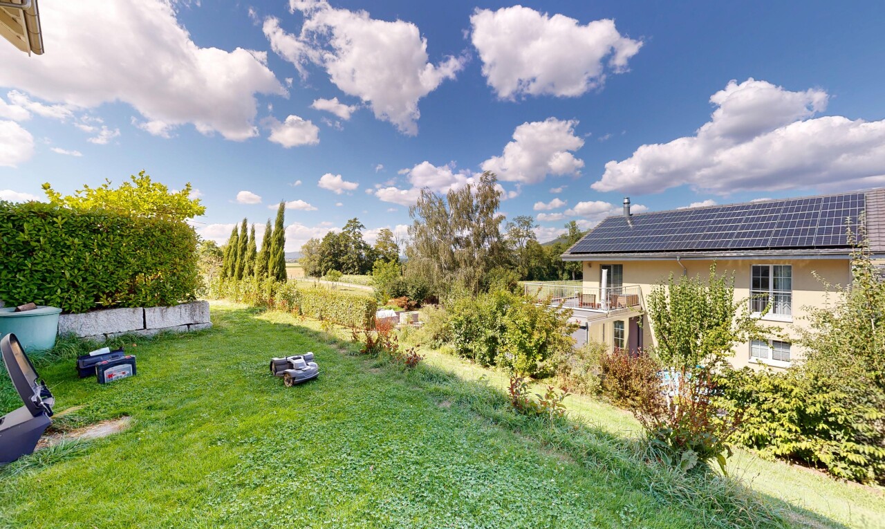 garden with a yard and roof mounted solar panels