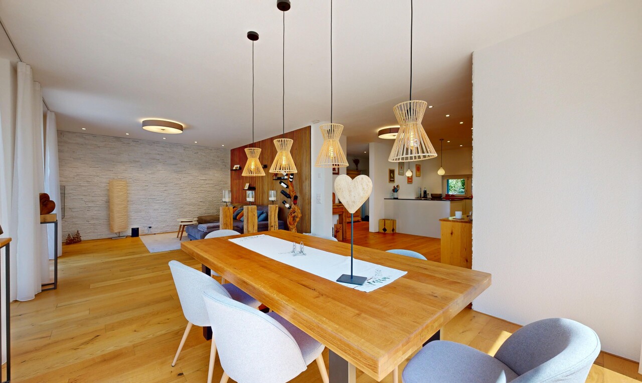 dining space with light wood-type flooring, decorative light fixtures, and an accent wall