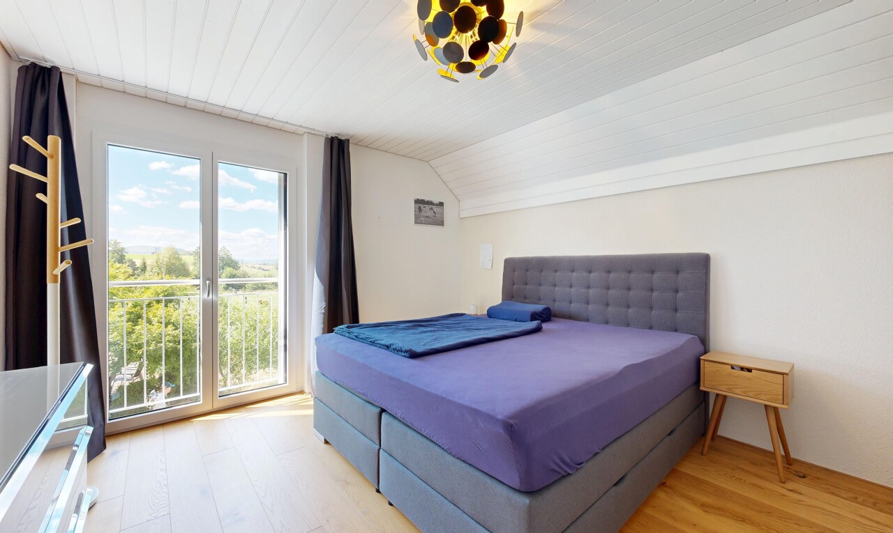 room with light wood finished floors, vaulted ceiling, and access to outside