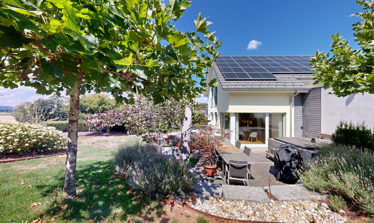 view of home with solar panels, a patio, and a yard