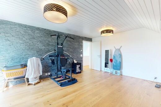 gym avec sol en finition bois, wood finish floor, mur en pierre, stone wall, et cloison sèche