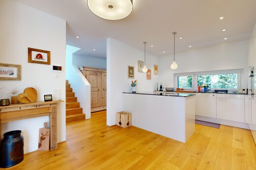 kitchen with hanging light fixtures, white cabinetry, light wood-style floors, a peninsula, and dark countertops