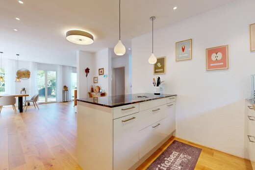 cuisine avec éclairage suspendu, light floor, pendant lighting, dark countertops, et wood finish floor