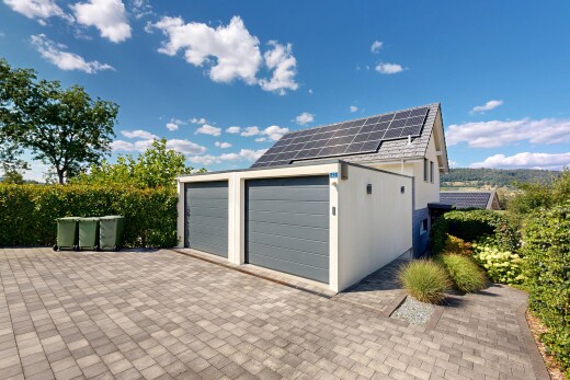 view of property with solar panels, driveway, and stucco siding