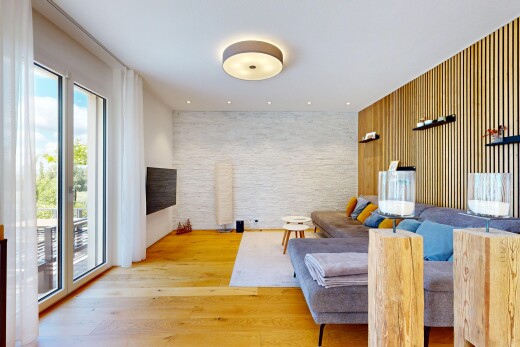 living area with an accent wall, light wood-type flooring, and wooden walls