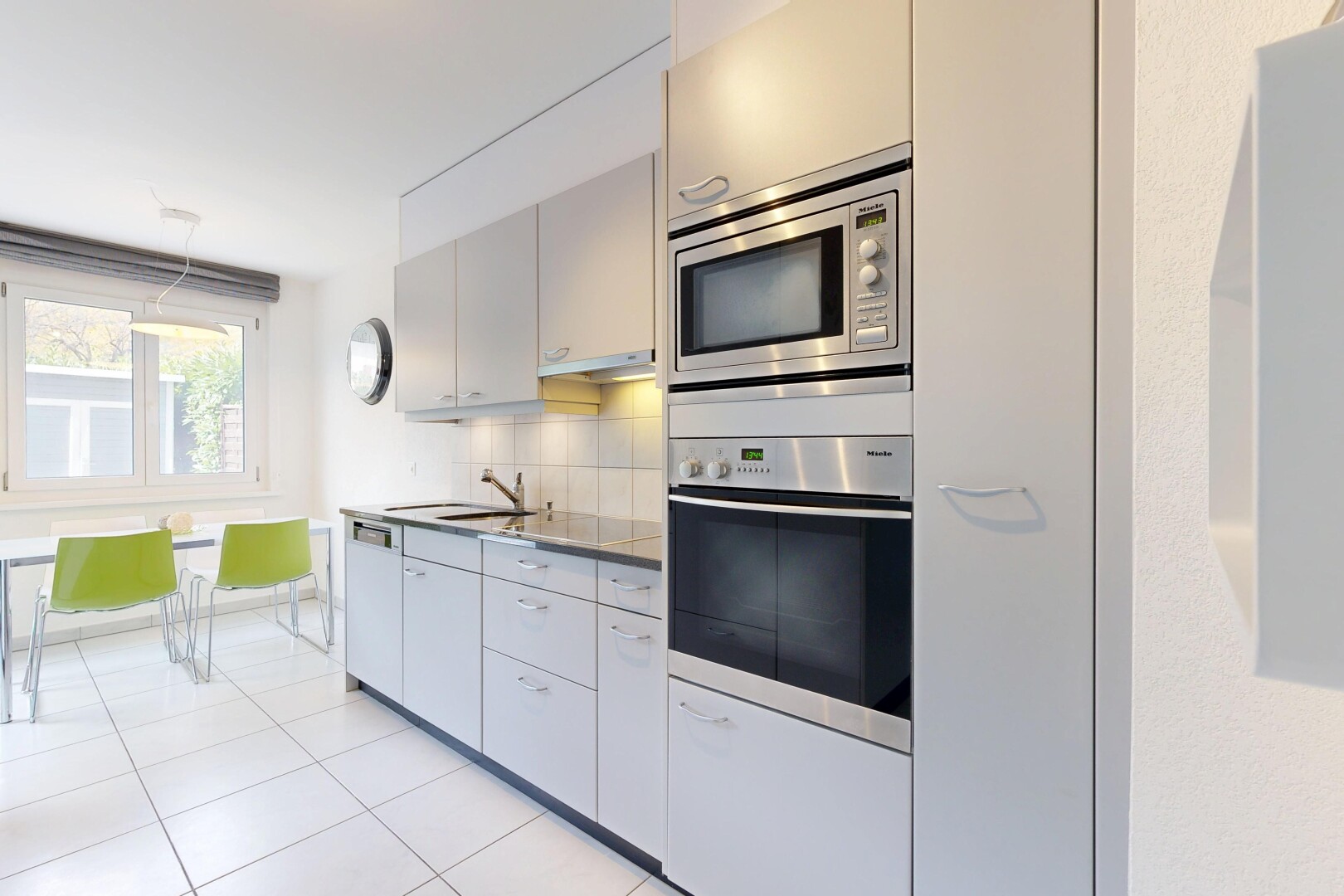 cuisine avec four, dosseret, backsplash, micro-ondes, et sol en carrelage