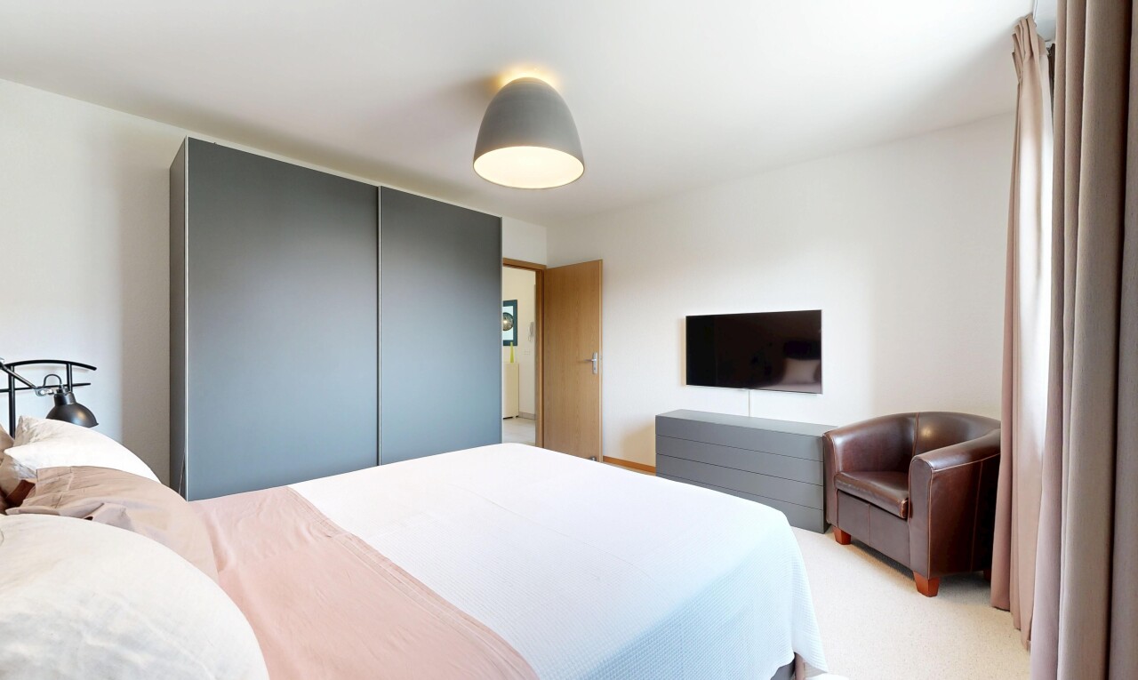 chambre avec télévision, cloison sèche, drywall, inside property, et moquette