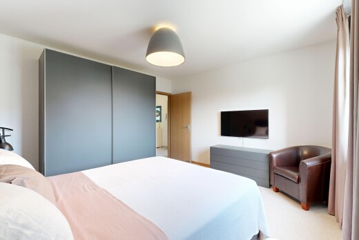 chambre avec télévision, cloison sèche, drywall, inside property, et moquette