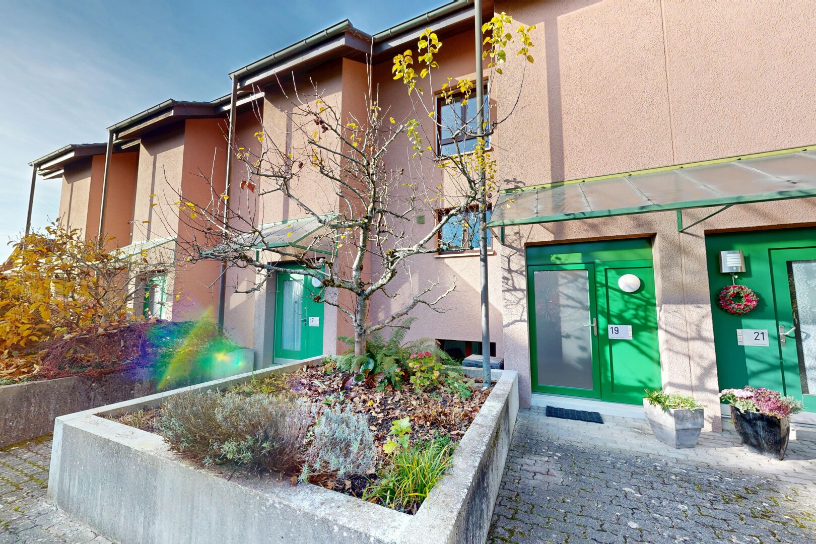 façade avec bardage en stuc, property visible, et day time