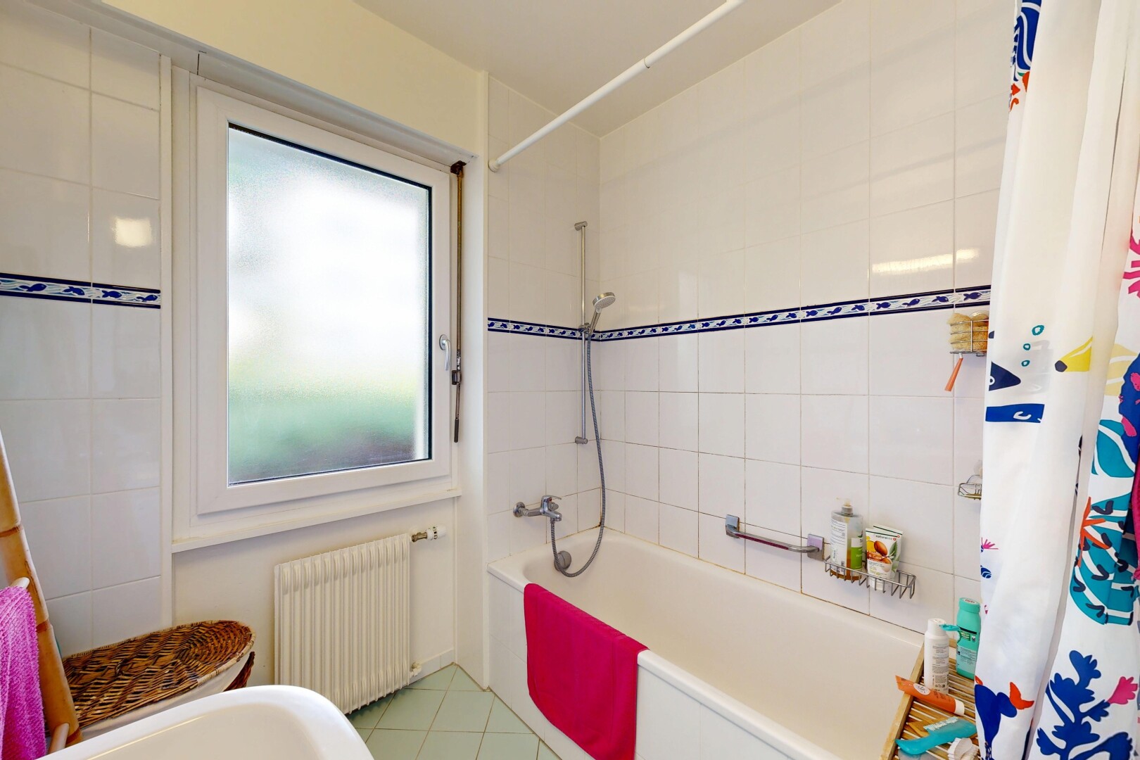 bathroom featuring radiator, shower / tub combo, and light tile patterned floors
