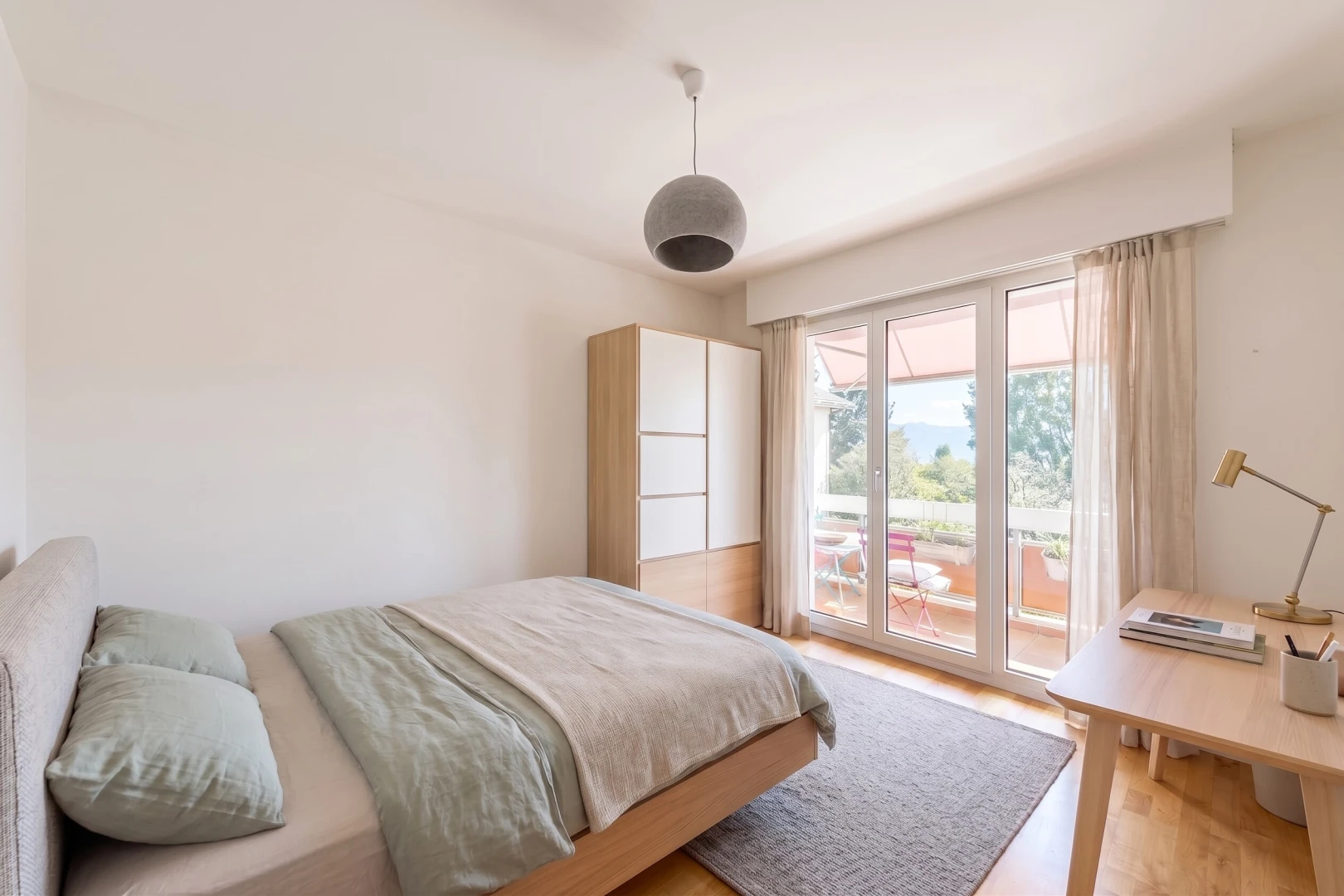 chambre avec accès à l'extérieur, cloison sèche, drywall, éclairage suspendu, et sol en finition bois