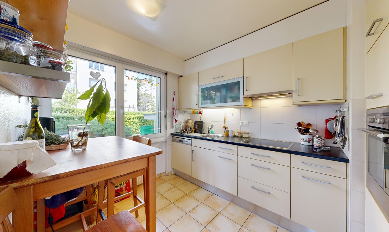 kitchen with dark countertops, backsplash, stainless steel dishwasher, black electric cooktop, and light tile patterned floors