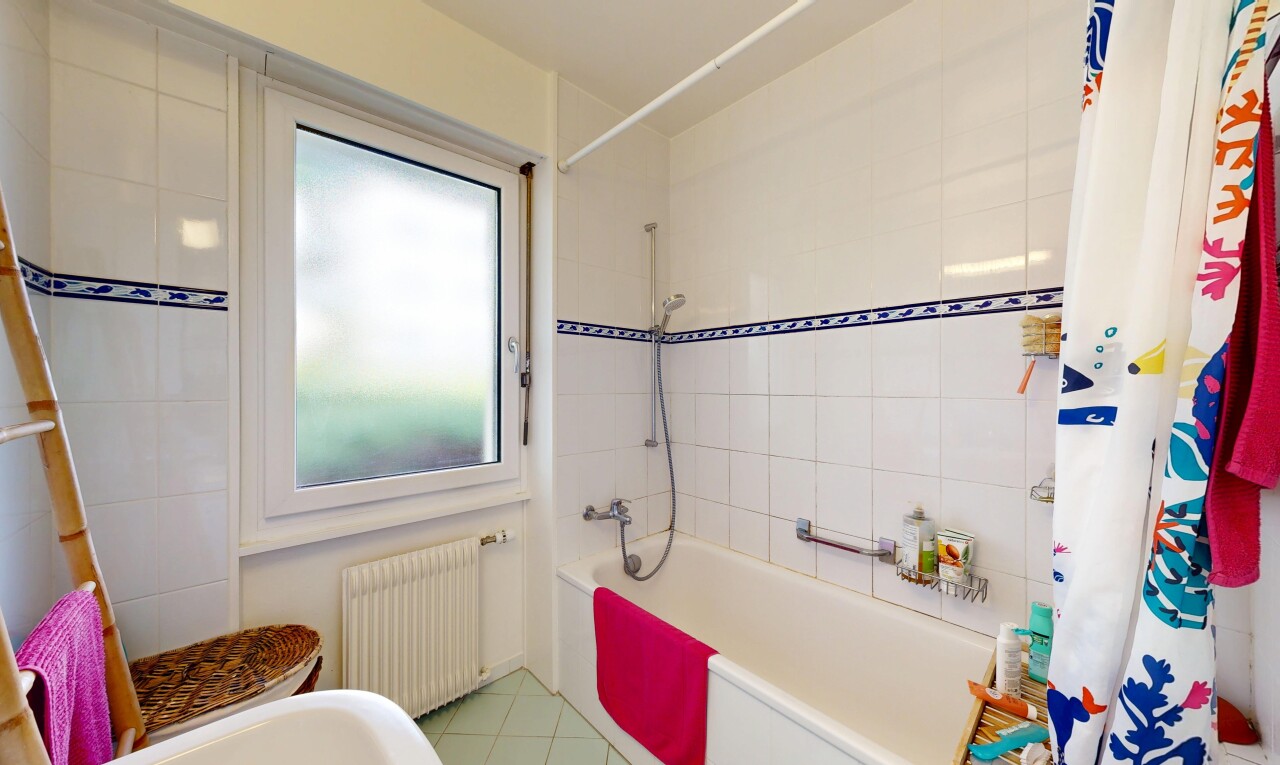 bathroom featuring radiator, shower / tub combo, and light tile patterned floors