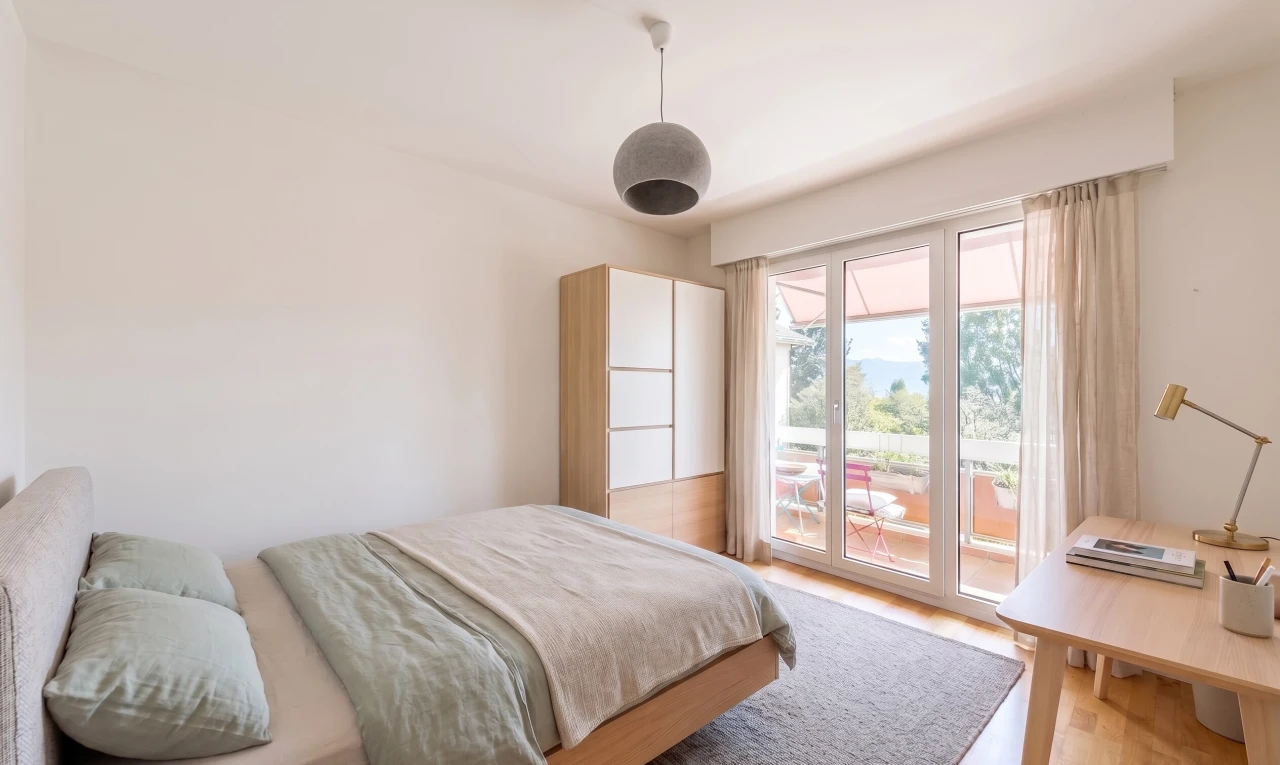 chambre avec accès à l'extérieur, cloison sèche, drywall, éclairage suspendu, et sol en finition bois