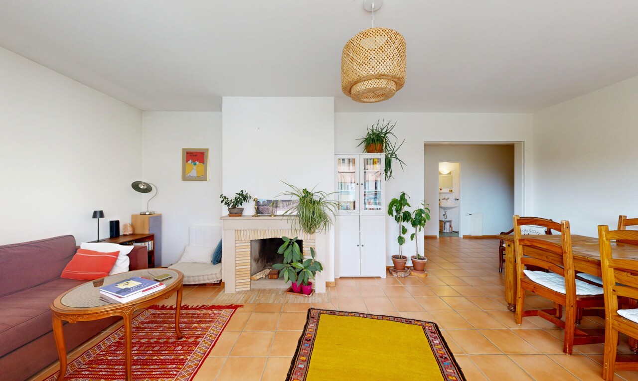 living room featuring a brick fireplace and light tile patterned floors