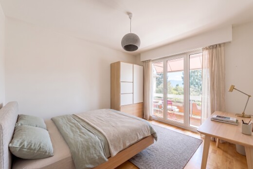 chambre avec accès à l'extérieur, cloison sèche, drywall, éclairage suspendu, et sol en finition bois