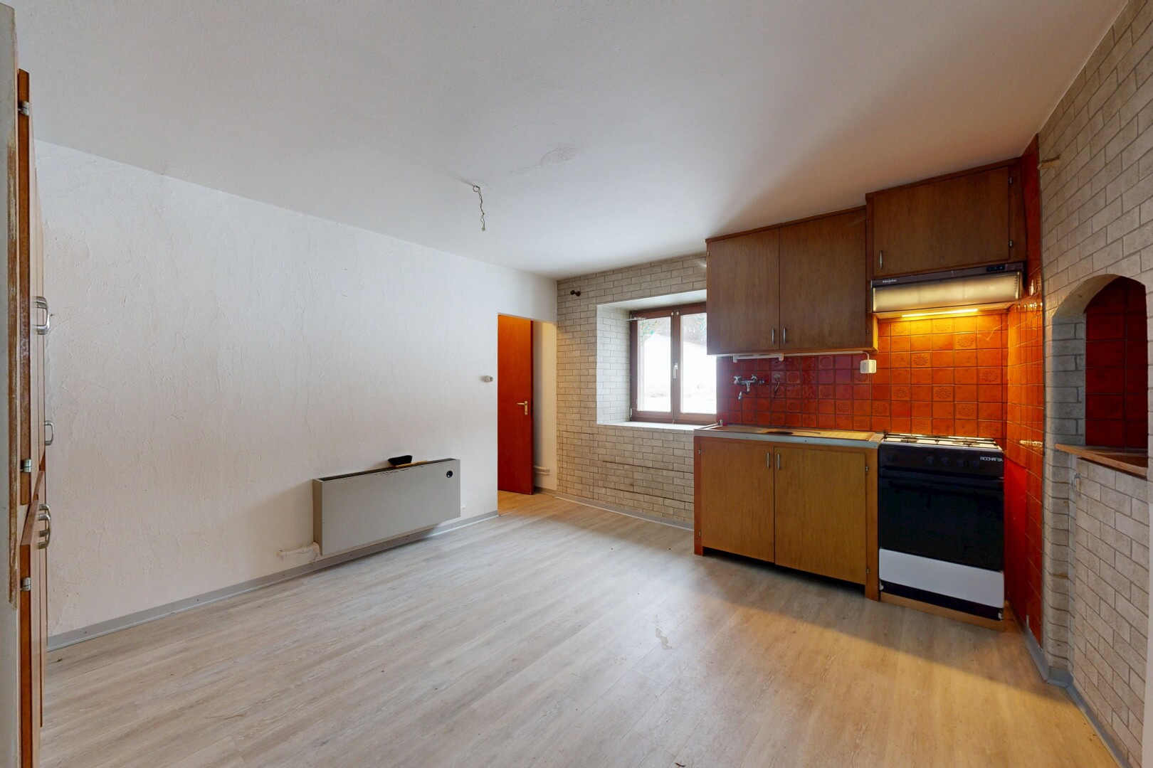 küche mit brick wall, ziegelwand, light floor, inside property, und dunstabzugshaube