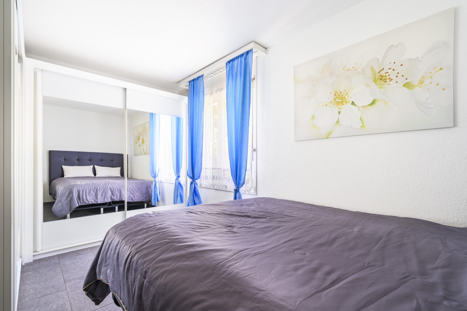 chambre avec inside property, tile floor, sol en carrelage, drywall, et natural light