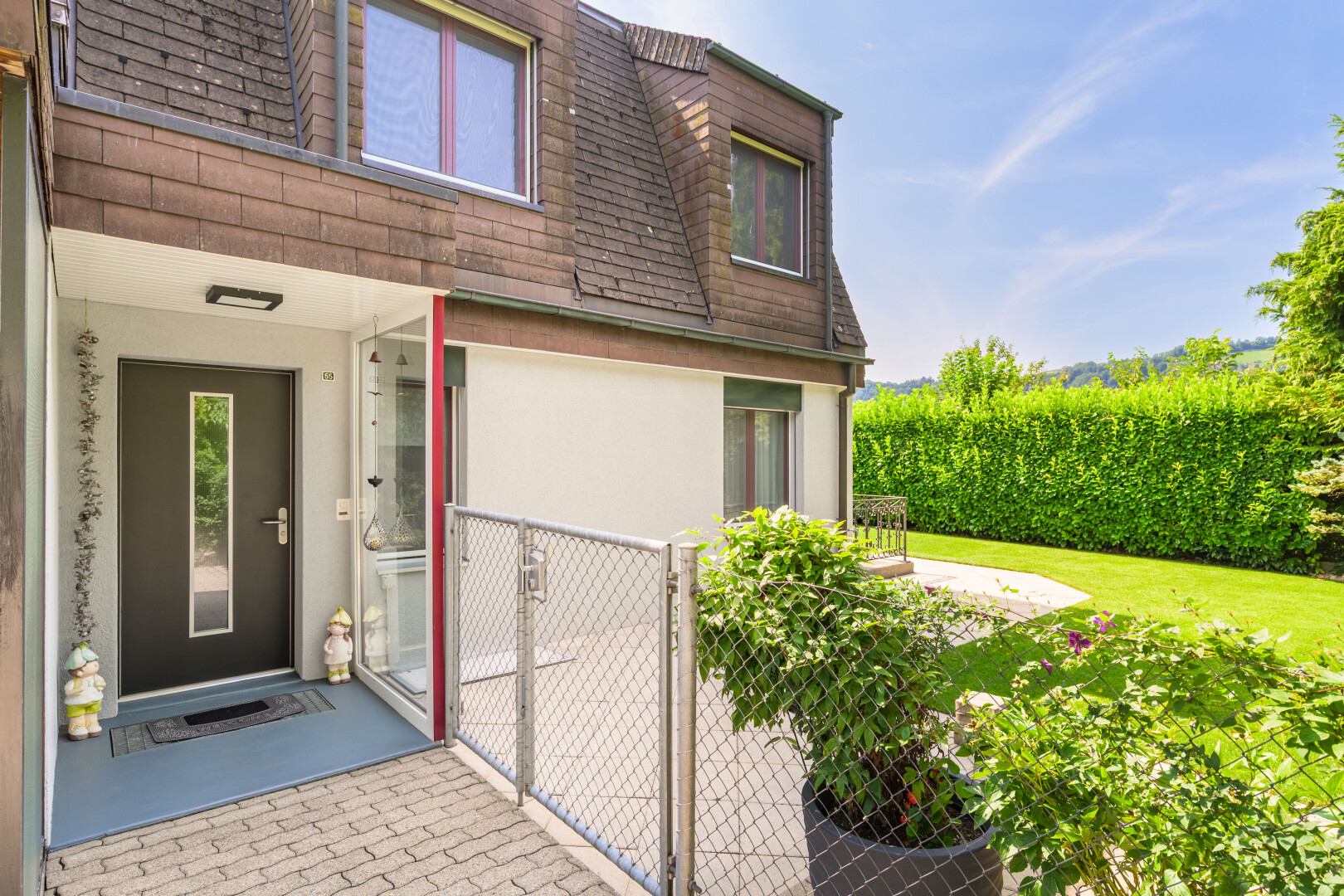 façade avec property visible, toit en bardeaux, portail, day time, et bardage en stuc