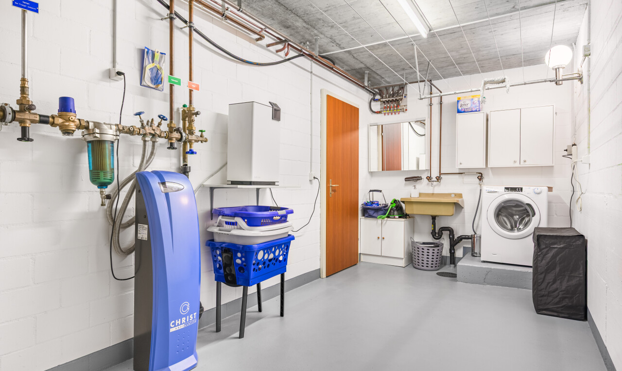 laundry area featuring concrete block wall, washer / clothes dryer, and cabinet space