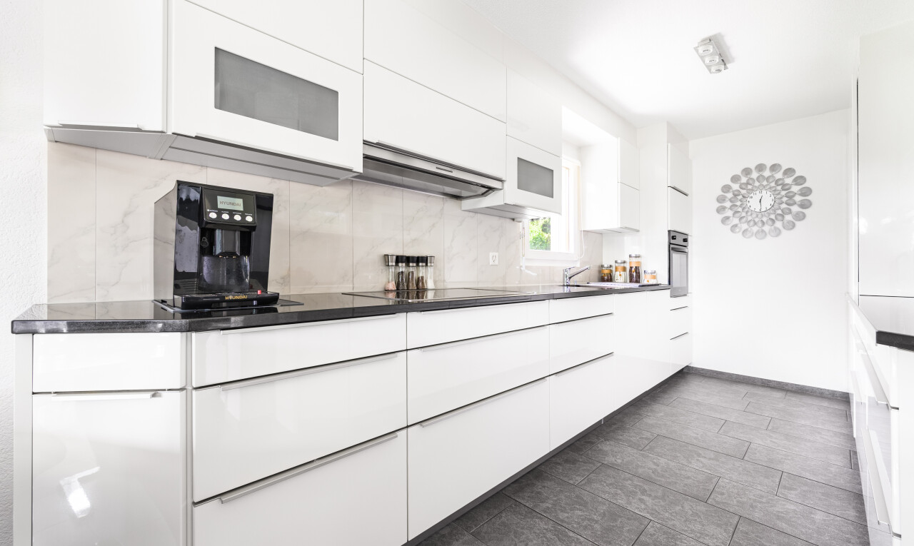 kitchen with white cabinets, modern cabinets, white microwave, backsplash, and oven