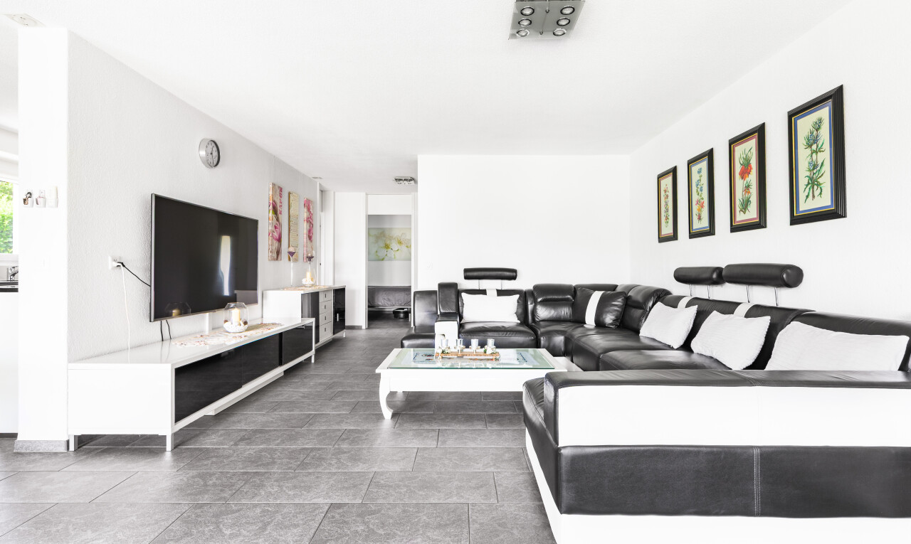 wohnzimmer mit fernseher, gipskartonwand, drywall, inside property, und natürliches licht