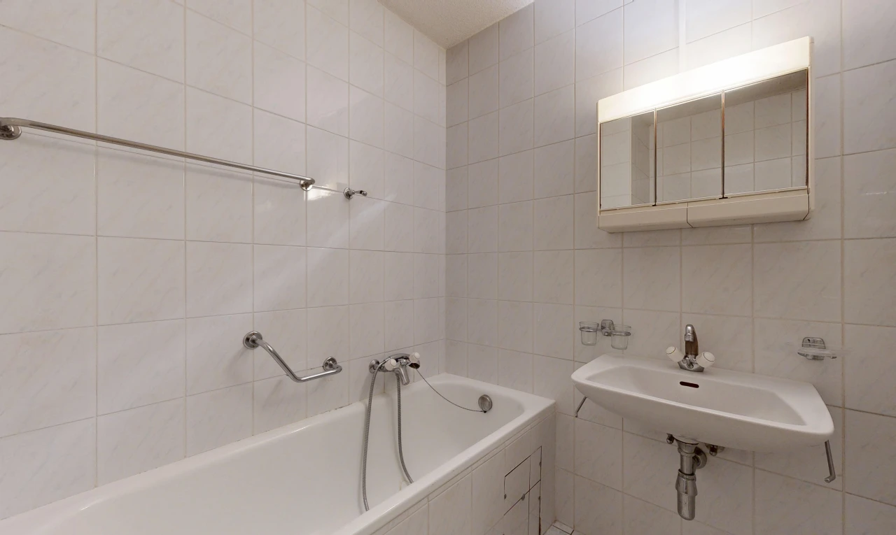 bathroom featuring a bath and tile walls