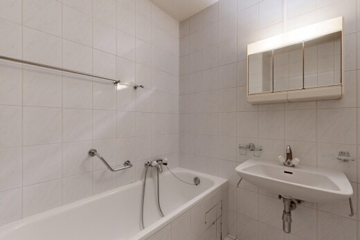 bathroom featuring a bath and tile walls