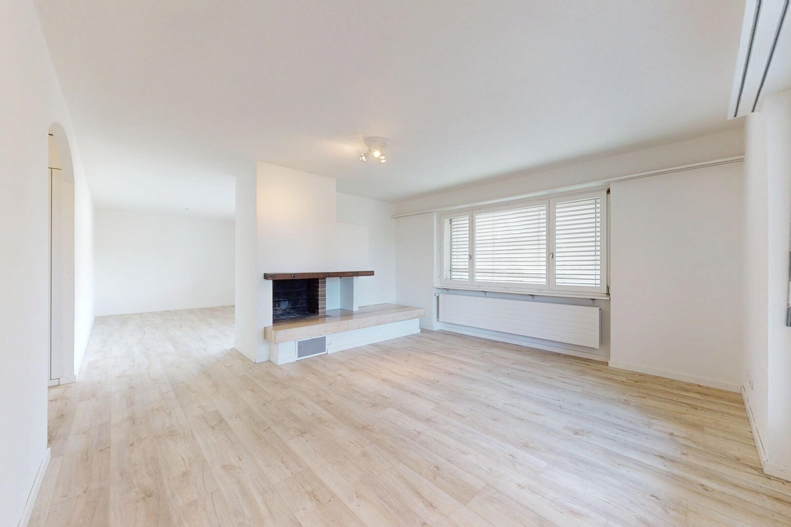 salon avec inside property, cloison sèche, drywall, cheminée, et sol en finition bois