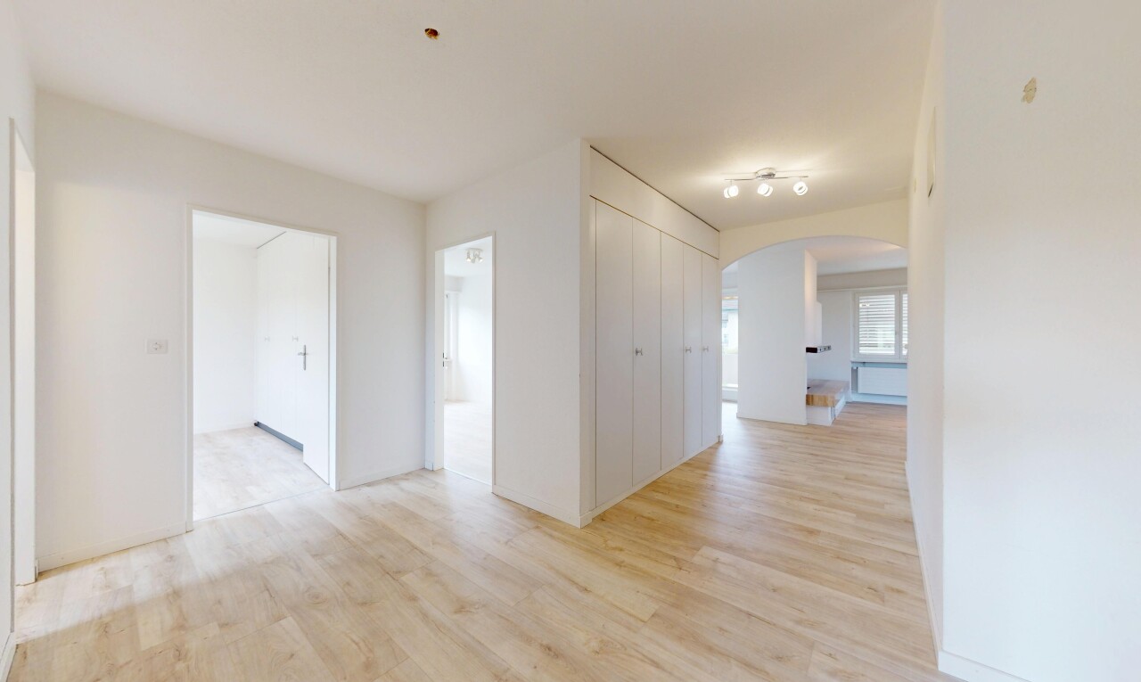 pièce vide avec passages en arc, sol en finition bois, wood finish floor, inside property, et cloison sèche