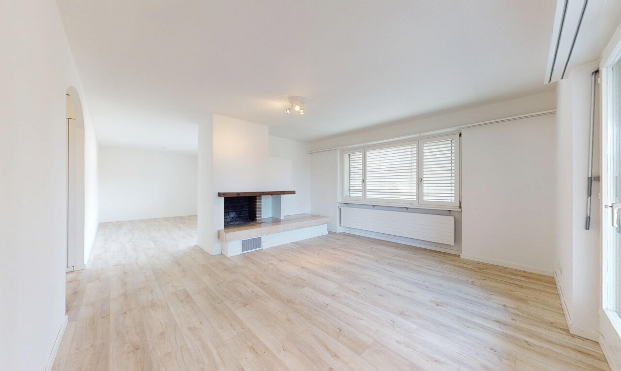 salon avec inside property, cloison sèche, drywall, cheminée, et sol en finition bois