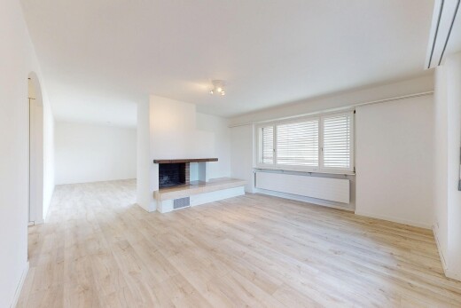unfurnished living room featuring a fireplace with raised hearth and wood finished floors