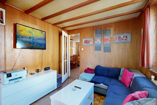 wohnzimmer mit fernseher, inside property, holzwand, und wood wall