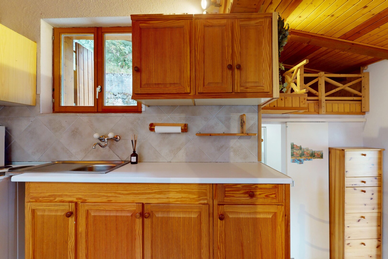 cuisine avec plans de travail, armoires marron moyen, inside property, armoires élevées, et lumière naturelle
