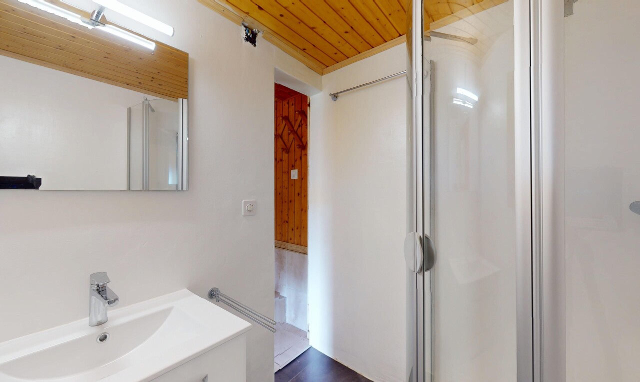salle de bains avec inside property, miroir, cloison sèche, drywall, et lavabo (ou coiffeuse selon le contexte)