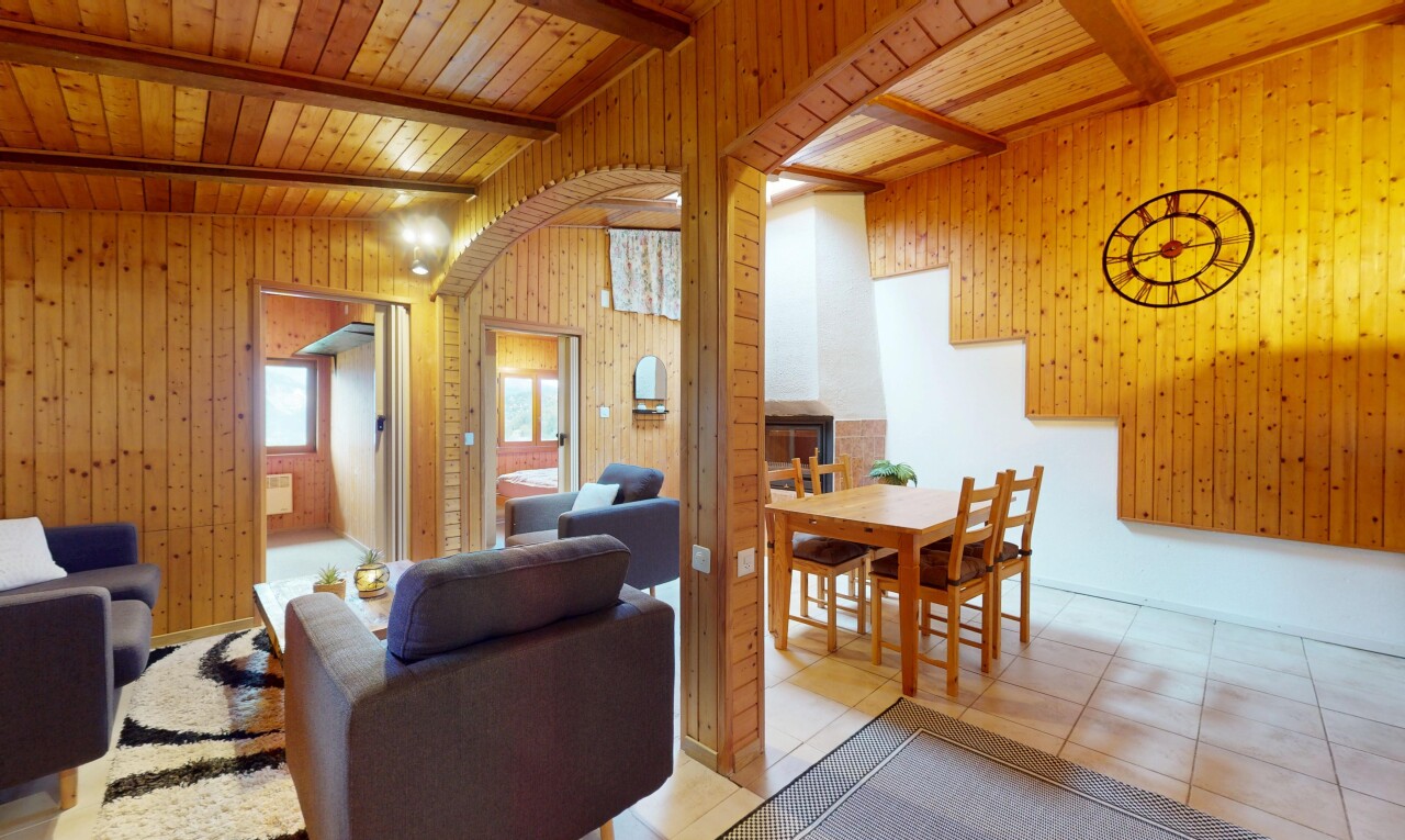 salon / salle à manger avec mur en bois, wood wall, lumière naturelle, natural light, et plafond à poutres