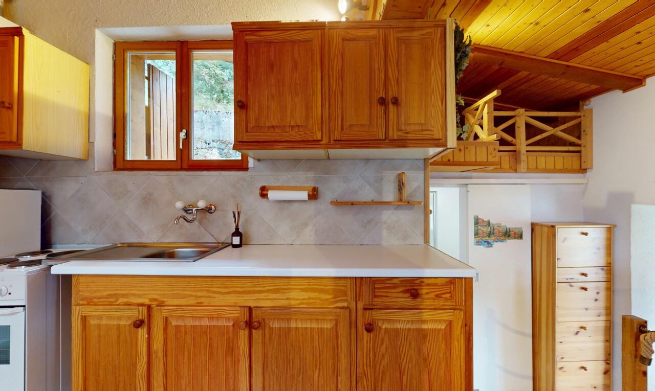 cuisine avec plans de travail, armoires marron moyen, inside property, armoires élevées, et lumière naturelle