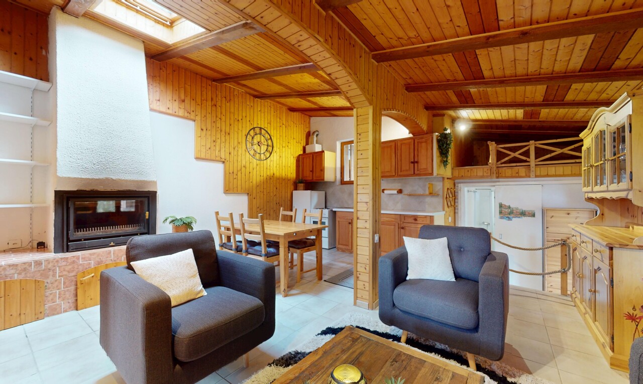 salon / salle à manger avec plafond à poutres, beamed ceiling, inside property, mur en bois, et wood wall